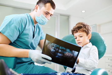 Boy child and dentist look at x-ray image