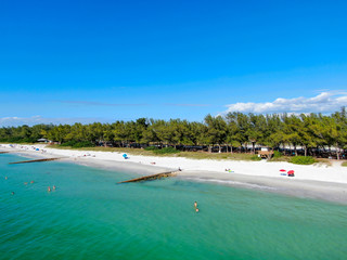 Fototapeta na wymiar Aerial view of Coquina Beach white sand beach and turquoise water in Bradenton Beach during blue summer day, Anna Maria Island, Florida. USA