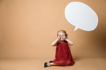 Girl sit on the floor on an orange background. Girl is very happy. Of the girl hanging blank white speech