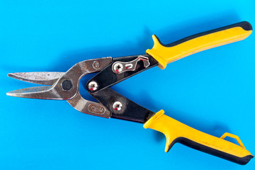 Scissors for metal. Tool for cutting sheet metal on a blue background.