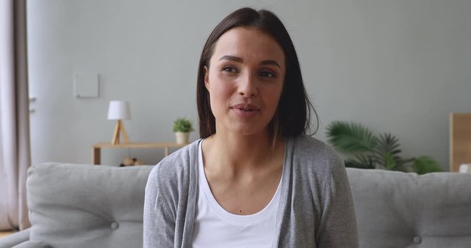 Young beautiful woman looking talking to camera at home
