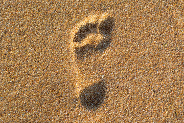 Traces of feet on the beach yellow sand. Footprints on the beach