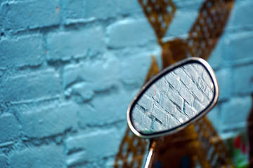 Obraz na płótnie Canvas Bike mirror against a blue brickstone wall
