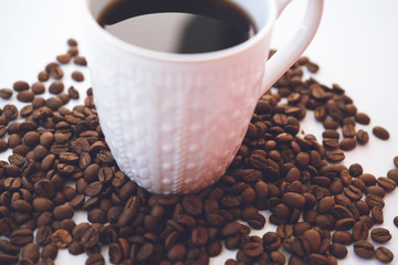White coffee cup and coffee beans on white background.
