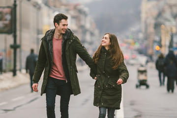 young couple, heterosexual boy and girl of Caucasian nationality, loving couple, walk around the center of country of European city in the middle of road on divided lane. Love and Romance Theme