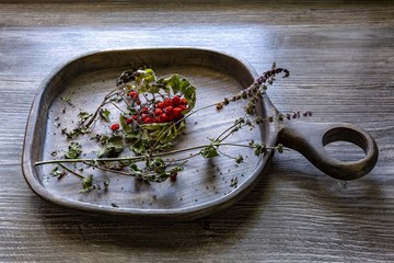 Dry rowan and mint on a wooden tray.