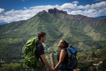 Backpacker couple holding hands surrounded by a natural landscape. Vilcabamba, Ecuador