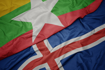 waving colorful flag of iceland and national flag of myanmar.