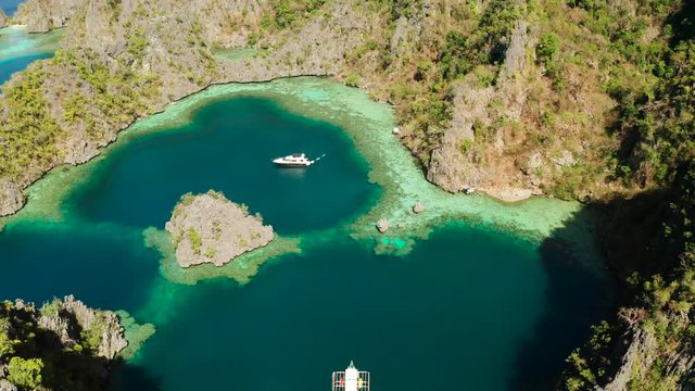 Aerial drone speed boat with tourists in beautiful lagoon. lagoons and coves with blue water among the rocks. Seascape, tropical landscape. Palawan, Philippines, Busuanga