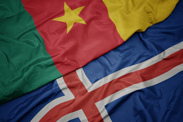 waving colorful flag of iceland and national flag of cameroon.
