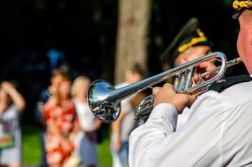 A man plays a wind musical instrument, trumpet close-up