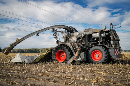 Ausgebrannter M&auml;hdrescher auf einen abgeernteten Feld