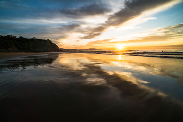 Obraz premium Beautiful scenic panoramic view of a colorful sunset on the beach at the Atlantic Ocean, in north of Spain, Europe