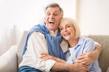 Senior couple laughing together, relaxing at home