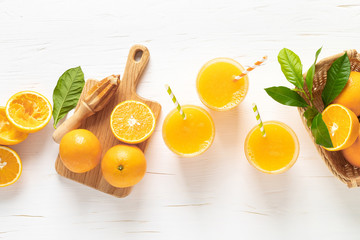 Orange juice. Freshly squeezed juice in glasses and fresh fruits with leaves, view from above