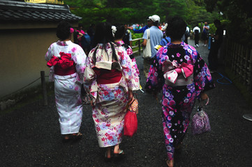 Fototapeta na wymiar Giovani ragazze giapponesi vestite con kimono si recano al tempio