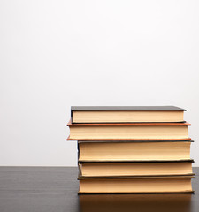 stack of books on a black table, white background