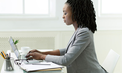 Office Girl Browsing On Laptop Sitting At Workplace, Side View