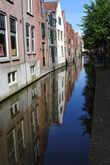 Fototapeta na wymiar Case colorate e a mattoncini si specchiano sul canale, Alkmaar una piccola venezia olandese