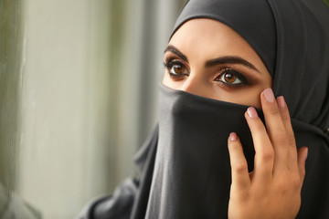 Portrait of beautiful Muslim woman near window