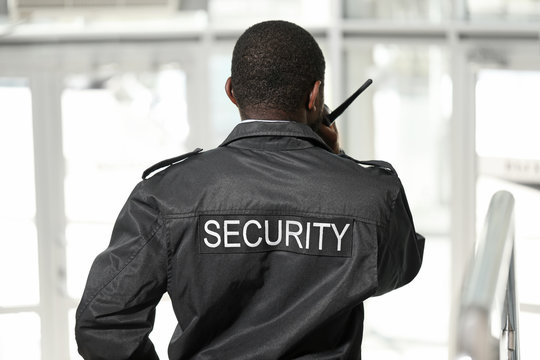 African-American security guard in building, back view