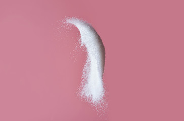 Throwing of sand sugar against color background