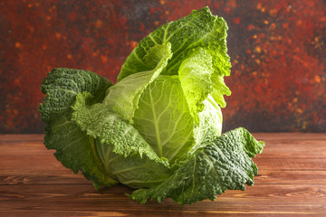 Fresh savoy cabbage on wooden table