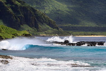 Breaking wave on the Beach with Mountains in the background