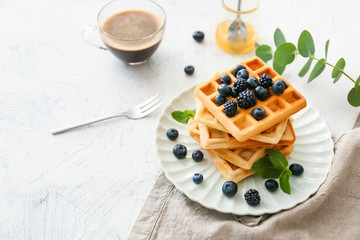 Plate with sweet tasty waffles on white table - obrazy, fototapety, plakaty