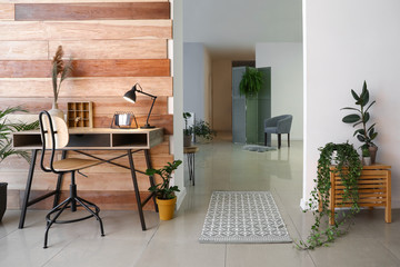 Stylish interior of studio apartment with green houseplants