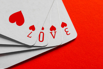 Word Love composed from playing cards on color background