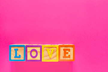 Word LOVE composed from cubes on color background