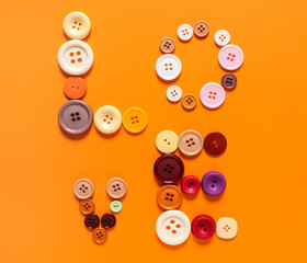 Word LOVE made of buttons on color background