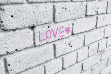 Word LOVE written on brick wall