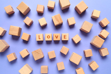 Fototapeta na wymiar Wooden cubes with text LOVE on color background