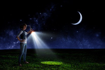 Obraz na płótnie Canvas Young woman holding a flashlight