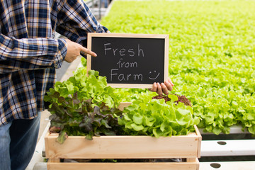 farmer holding small blackboard with word of fresh from farm in hydroponic farming
