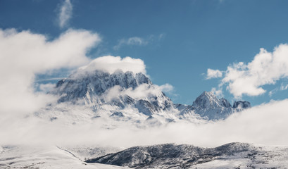 Fototapeta na wymiar Panoramic snow mountain with white clouds and blue sky 
