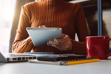 Businessman hands working with finances about cost and calculator and laptop with tablet, smartphone at office in morning light