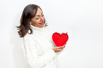 Happy beautiful woman holding a red heart on her hands isolated on white background. Conceptual for love, healthcare, cardiology.