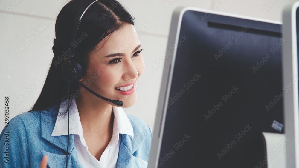 Poster customer support agent or call center with headset works on desktop computer while supporting the cu