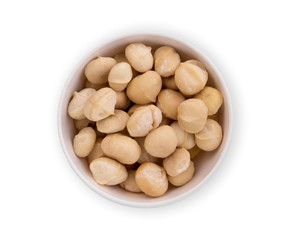shelled macadamia fruit in the white bowl isolated on white background, flat lay, top view