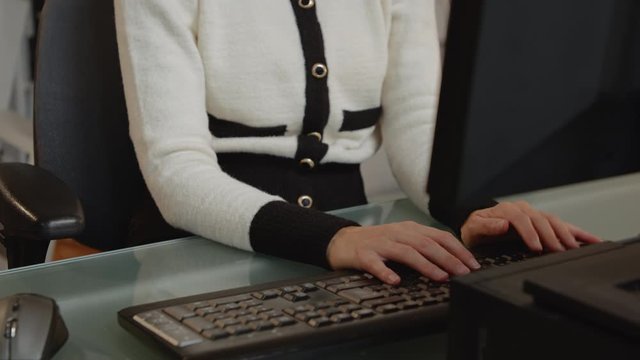 Young businesswoman using her mouse to browse the Internet and working in her home office