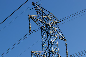 Large Industrial Energy Tower With Wires Supplying Power With Blue Sky Background