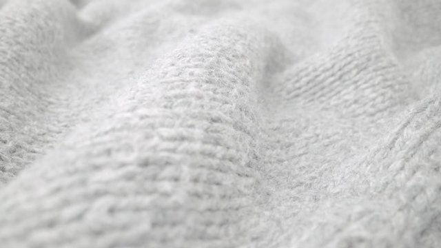 Extreme detail view of sheep wool cloth texture in macro dolly shot. Flowing animal fiber material for handcraft knitting. Textile abstract background. Winter fashion clothing industry concept.