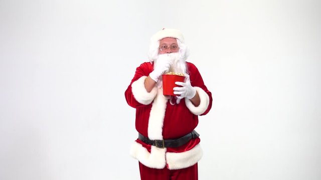 Christmas. Santa Claus on a white background with a red bucket with popcorn. There is popcorn, watching movies, emotions, fear, fun.