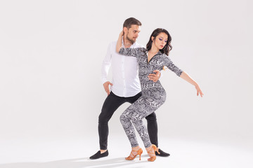 Young couple dancing social latin dance bachata, merengue, salsa. Two elegance pose on white background with copyspace