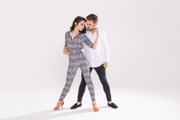Young couple dancing latin dance bachata, merengue, salsa, kizomba. Two elegance pose over white background with copy space
