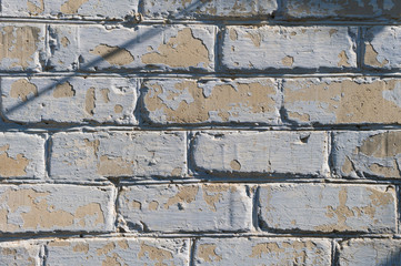 Close-up of an old painted peeling cracked brick