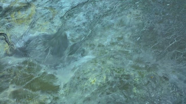 Aerial view; drone flying forward over a polluted river with destroyed ecosystem and copper tailing dump poisoning ground and water; air emissions from industry; environmental disaster in South Ural